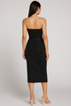 Black strapless dress worn by a model on a light gray background