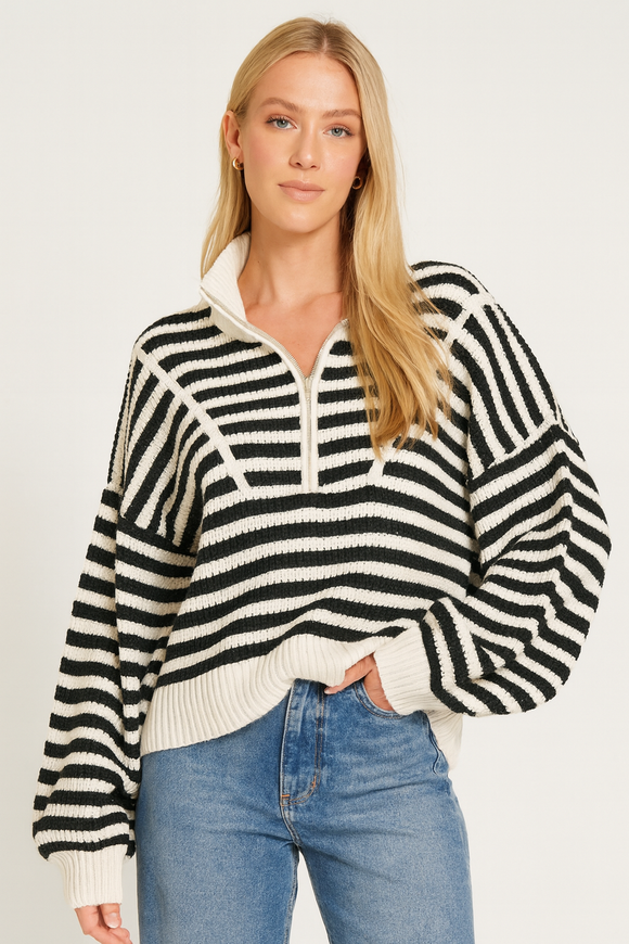 Woman wearing a black and white striped sweater with a plain background