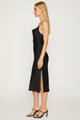 Woman wearing a black one-shoulder dress with a slit on a white background