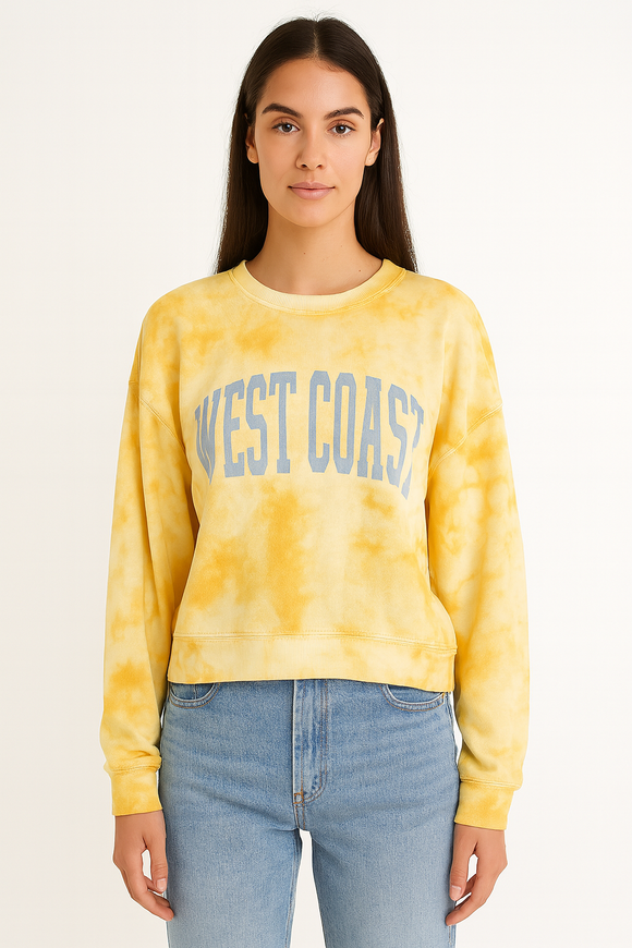 Woman wearing a yellow tie-dye sweatshirt with 'WEST COAST' text on a plain background