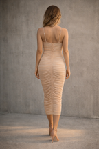 Woman wearing a beige dress against a gray background