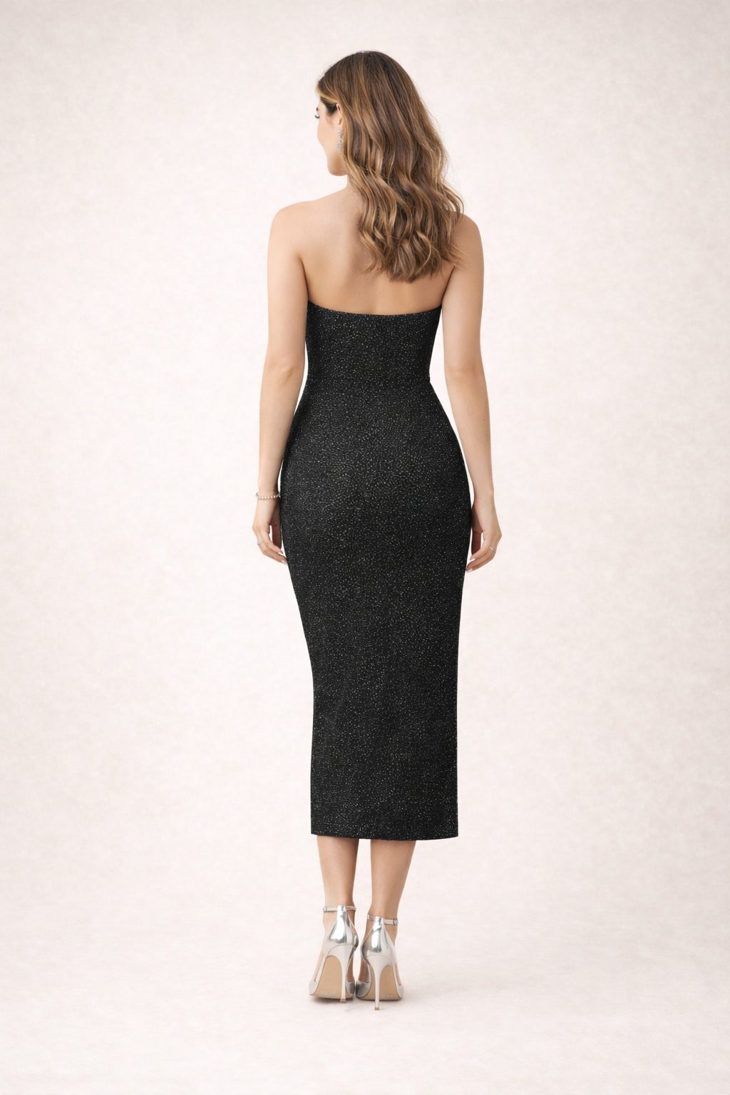 Woman wearing a black strapless dress on a white background