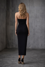 Woman wearing a black strapless dress against a gray background