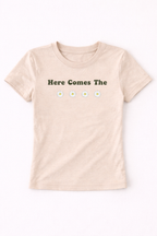 Beige t-shirt with 'Here Comes The' text and daisy flowers on a white background