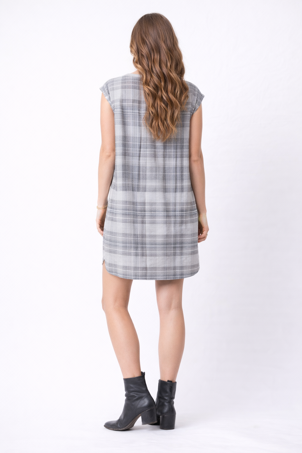 Woman wearing a plaid dress with a plain white background